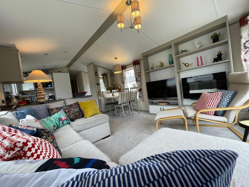 a living room with a couch and a tv at Seton Sands Caravan Near Edinburgh & North Berwick in Port Seton