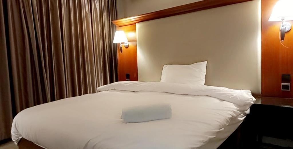 - un grand lit blanc dans une chambre d'hôtel dans l'établissement P.A.S.H.A BOUTIQUE HOTEL, à Amman