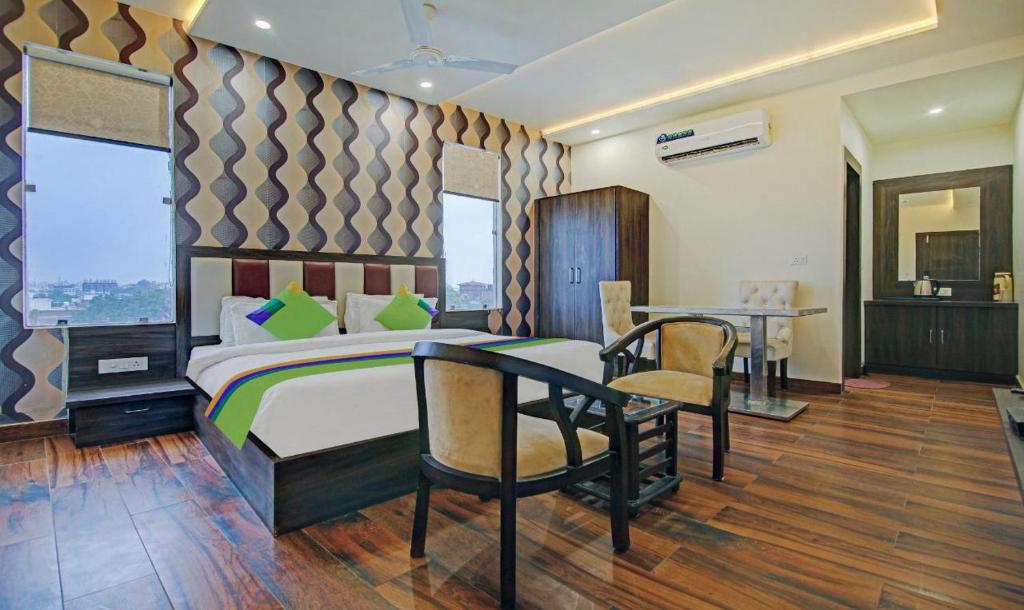 a bedroom with a bed and a table and chairs at Hotel Spiritual Land in Mathura
