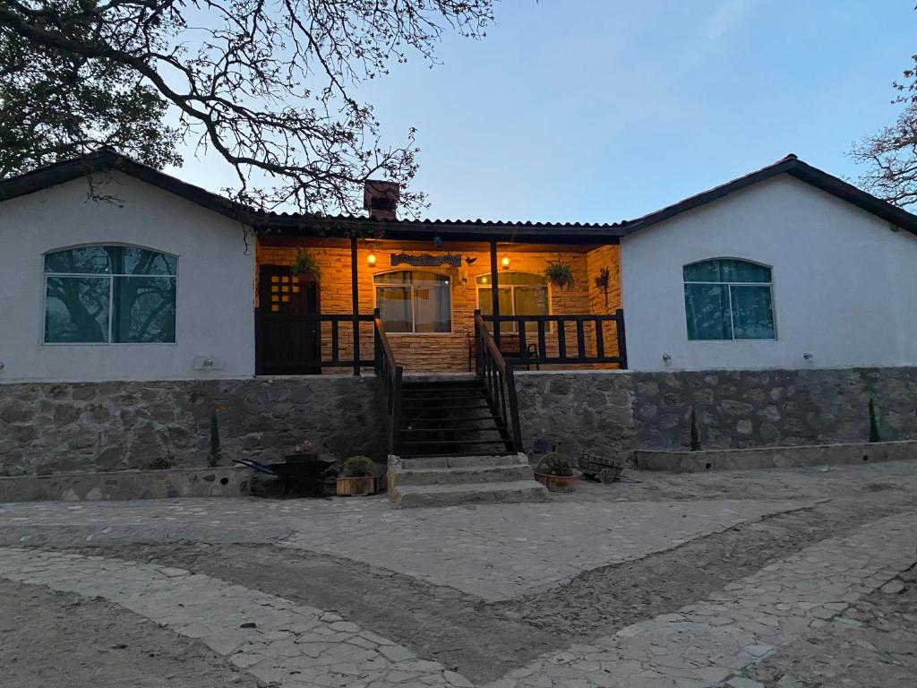 een wit huis met een stenen muur bij Cabañas La lunada in Las Palomas