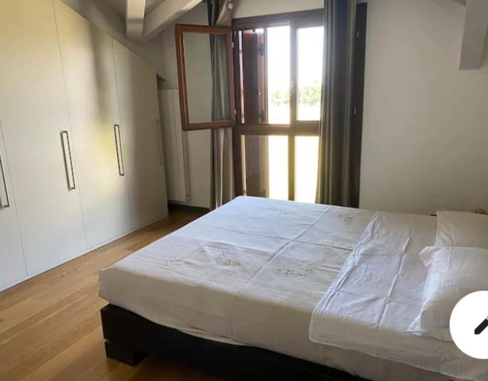 uma grande cama branca num quarto com uma janela em Stupendo appartamento em Mozzo