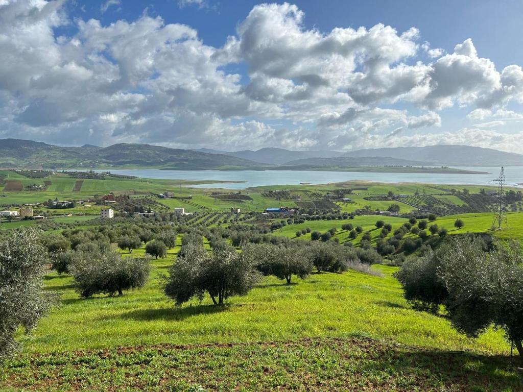 a green field with a lake in the distance at La Belle Etoile in Ouazzane