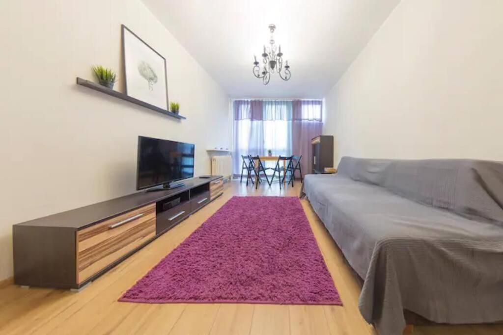 a bedroom with a large bed and a pink rug at UrbanNest_Pereca in Warsaw