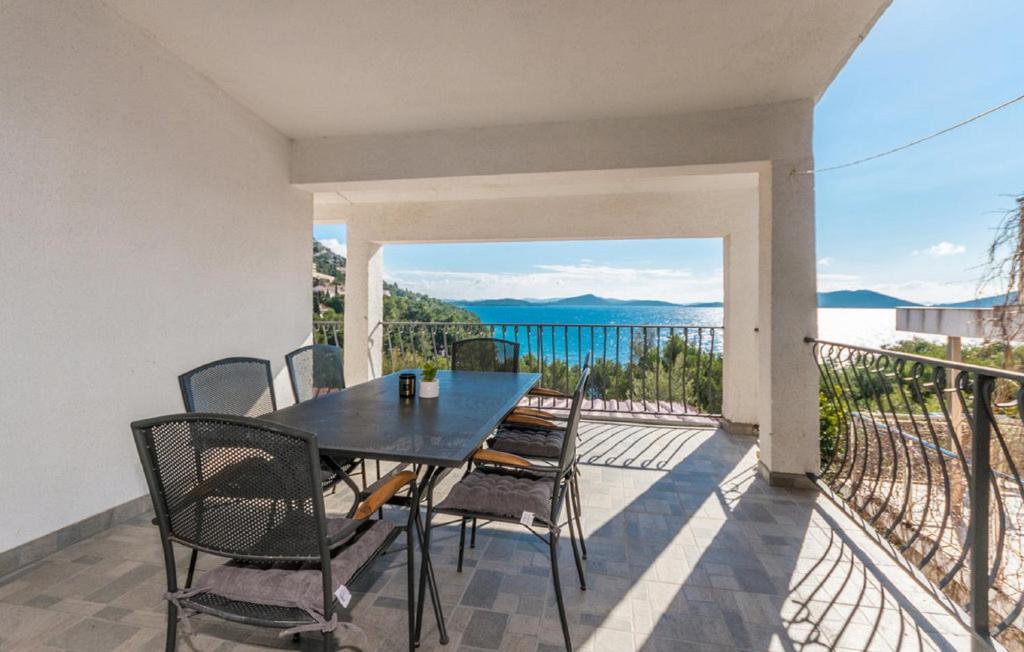 een tafel en stoelen op een balkon met uitzicht op het water bij MY DALMATIA - Beachfront apartment Vanja with sea view terrace and private parking in Drage