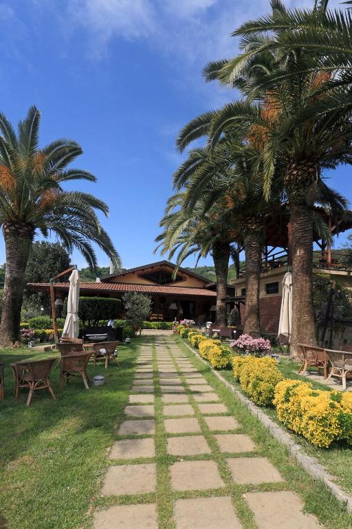 a walkway in a park with palm trees and benches at Il Borgo sul Lago in Pizzo