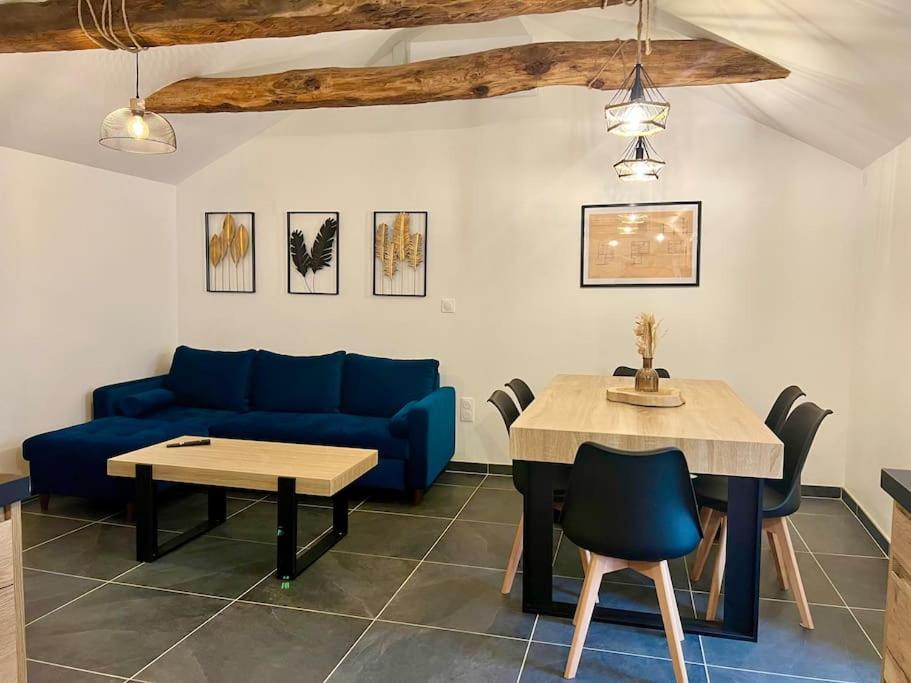 - un salon avec un canapé bleu et une table dans l'établissement Appartement Nicolas, à Aujac