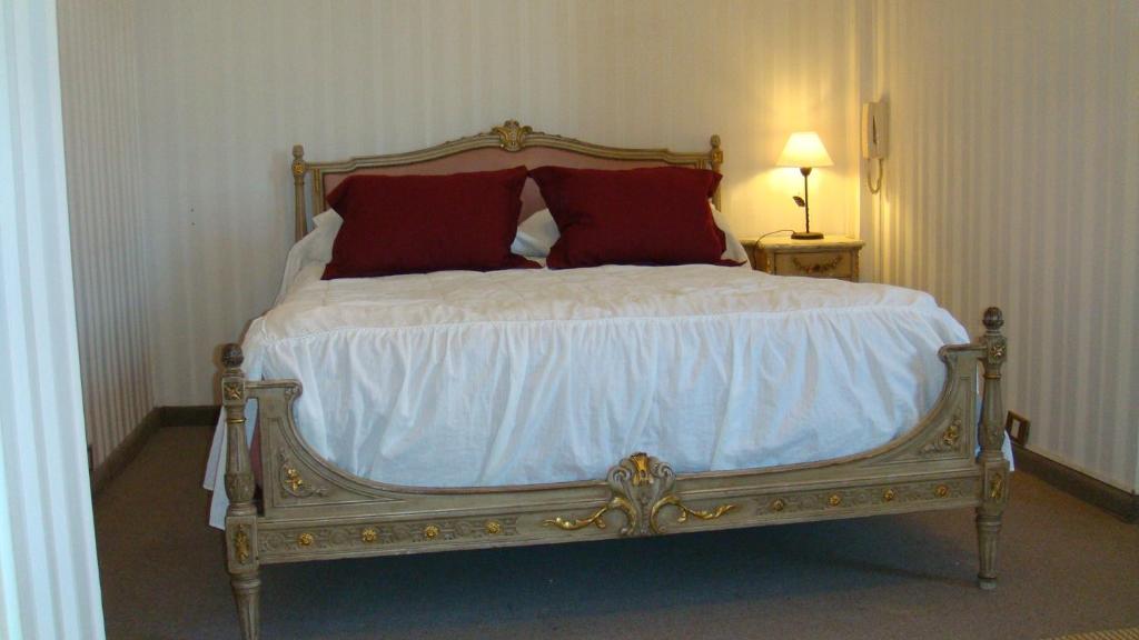 a bed with two red pillows on it in a room at Obelisco Apartment in Buenos Aires