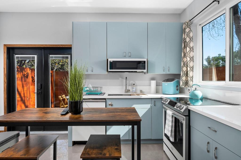 une cuisine avec des placards bleus et une table en bois dans l'établissement Private Studio in La Mesa, à La Mesa