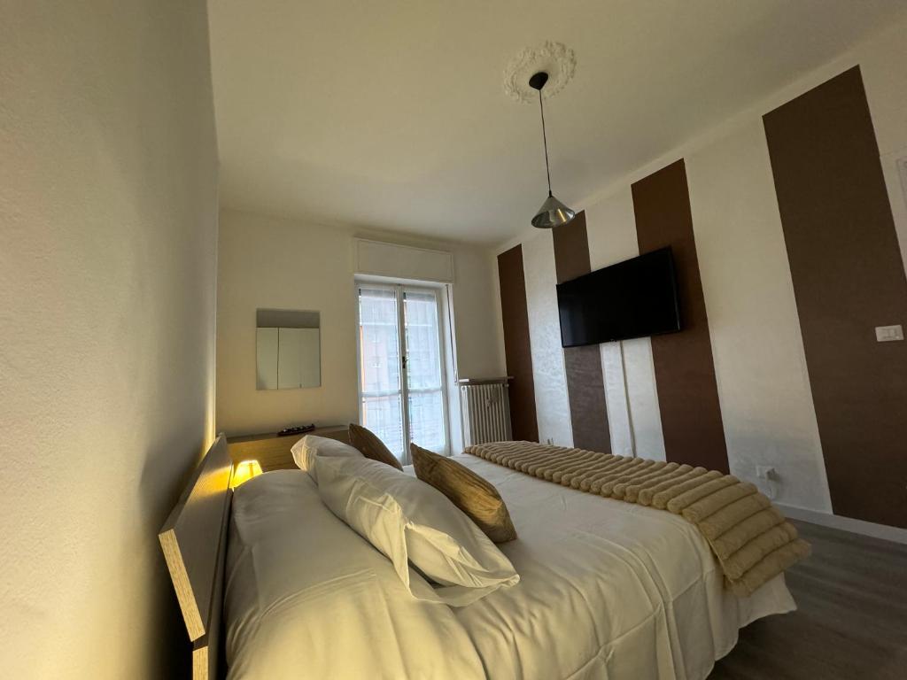 1 dormitorio con 2 camas y TV en la pared en La Petite Maison, en Gaglianico