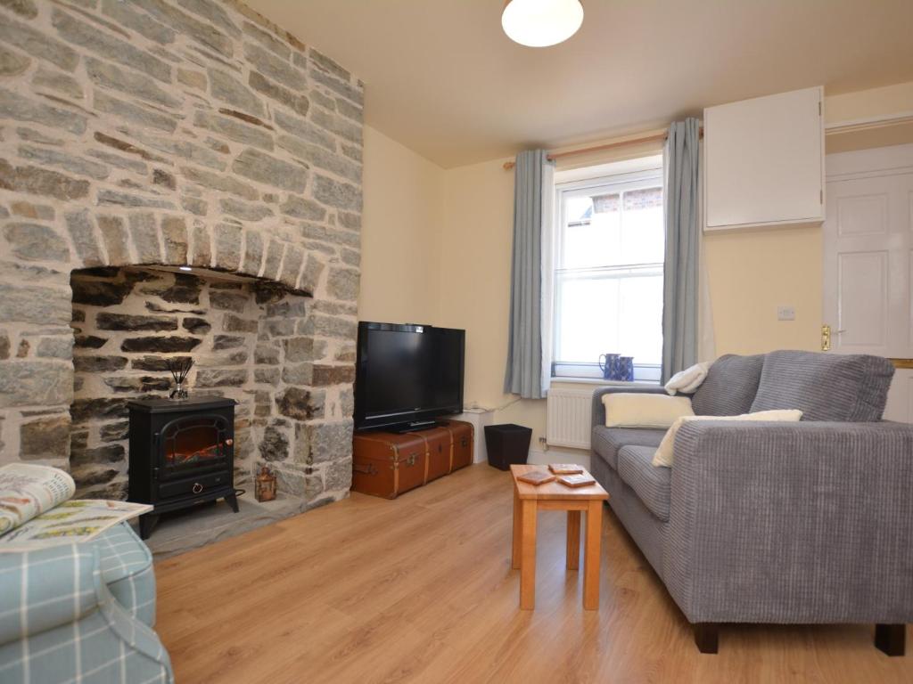 a living room with a couch and a stone fireplace at 2 Bed in Knighton 62209 in Knighton