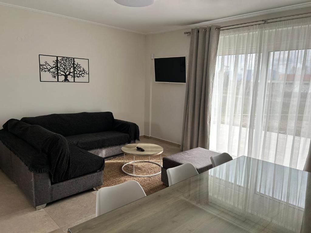 a living room with a black couch and a glass table at TEGEA LUXURY SUITES Athena in Tripolis