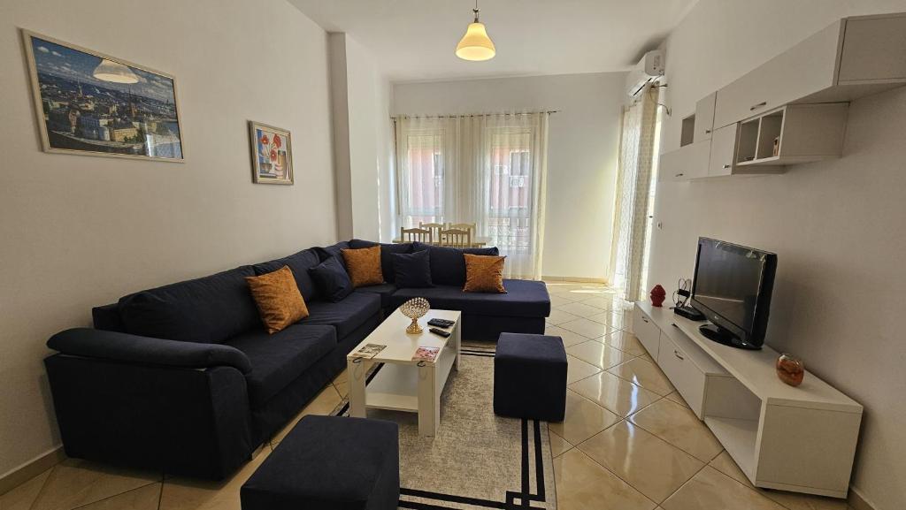 ティラナにあるTirana Bosco's Apartamentの青いソファとテレビのあるリビングルーム