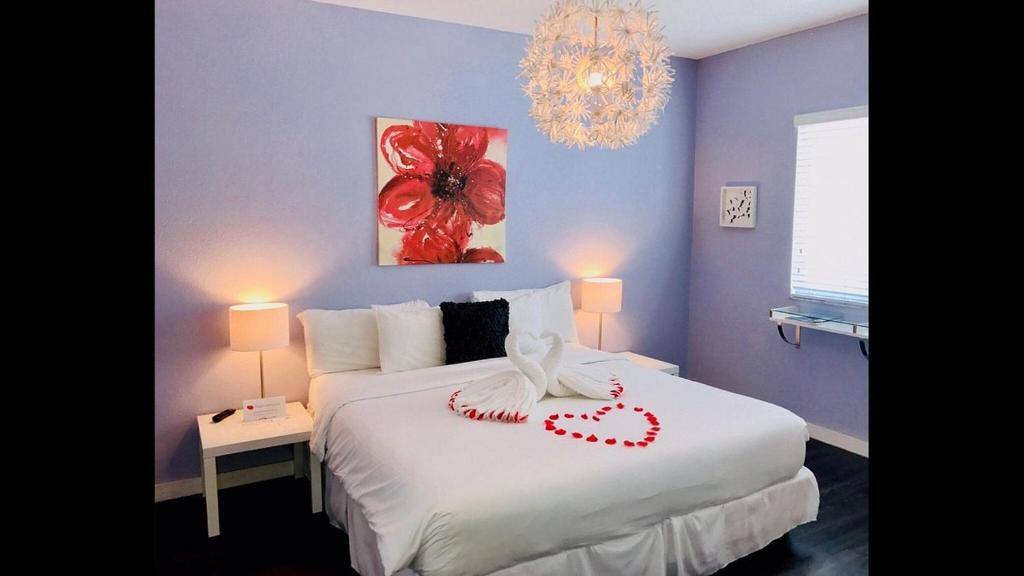 a bedroom with a white bed with a heart on it at M HOTEL in Miami Beach