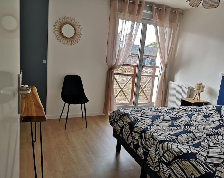 une chambre avec un lit, une fenêtre et une chaise dans l'établissement Maison Jasmin-Citrus, à Saint-Valery-sur-Somme