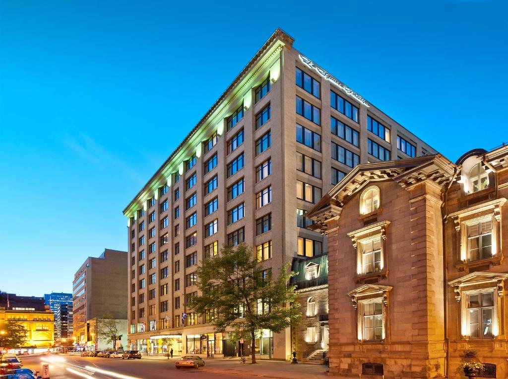 a tall building on a city street at night at Le Square Phillips Hôtel & Suites in Montreal