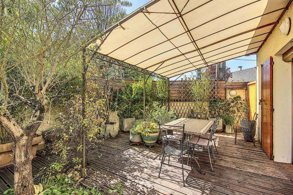 a wooden deck with a table and chairs and an umbrella at Gîte de France Bayat 4 épis - Gîte de France 5 personnes 354 in Varetz