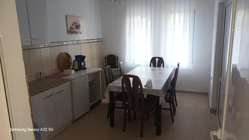 uma cozinha com uma mesa e algumas cadeiras e uma mesa e uma cozinha em Appartment Utjeha em Utjeha