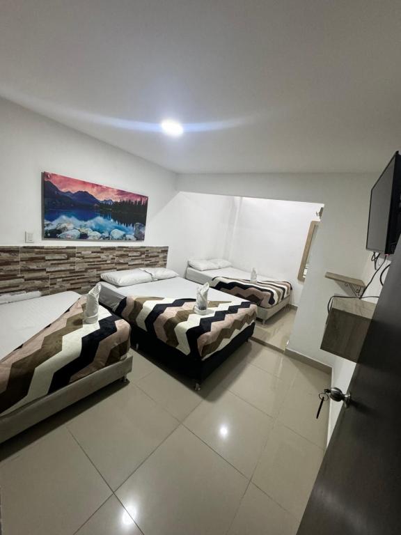 a room with two beds and a tv in it at HOTEL SELECT in Medellín