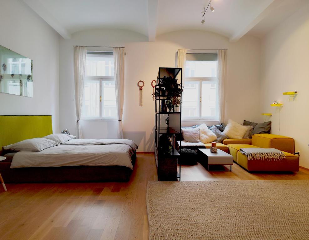 a living room with a bed and a couch at Very cosy and quiet Apartment at Stadtpark in Vienna