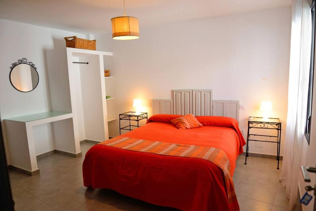 um quarto com uma cama com um cobertor vermelho em 4 bedrooms house with wifi at Almagro em Almagro