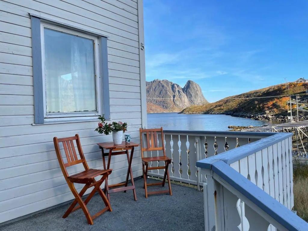 - un balcon avec vue doté de 2 chaises et d'une table dans l'établissement Reinestua, à Moskenes