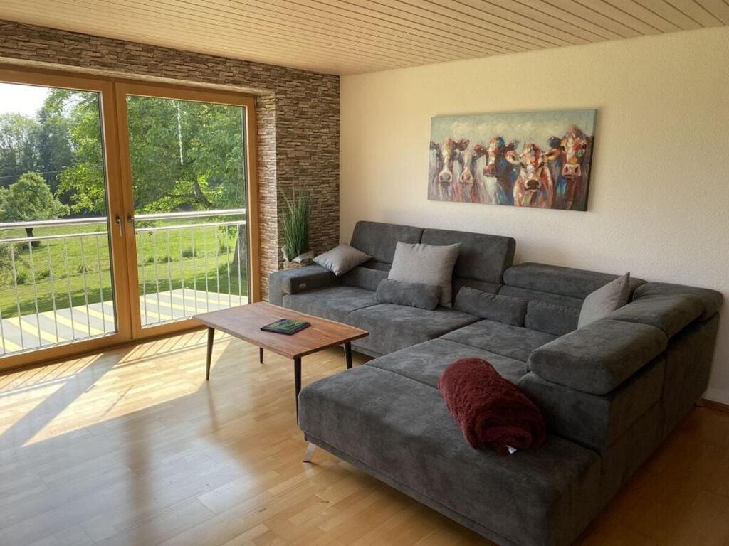 a living room with a couch and a table at Appealing apartment near lake in Argenbühl