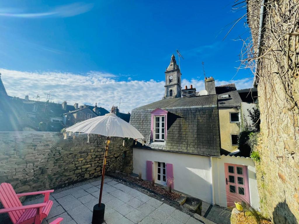 un parasol installé sur une terrasse à côté d'un bâtiment dans l'établissement Ty Bonbon, petit cocon avec jardin hyper centre, à Vannes