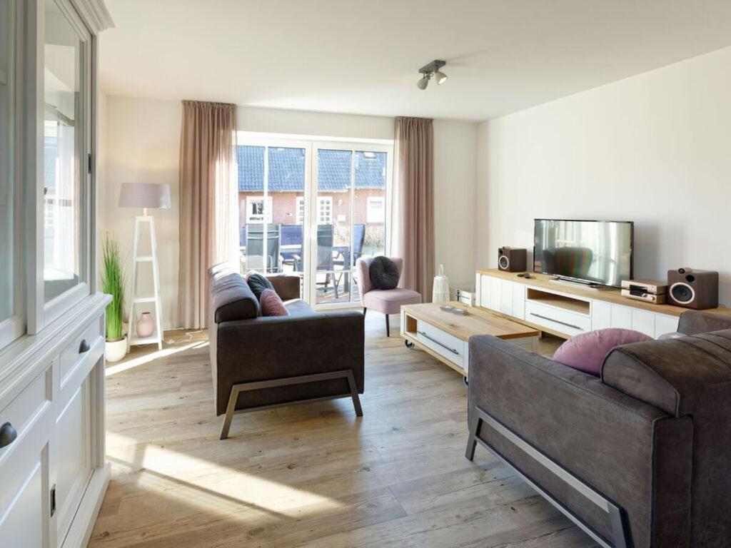 a living room with a couch and a table at Beach House Langeoog in Langeoog