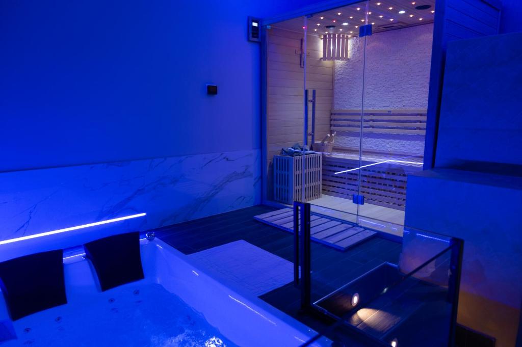 a bathroom with a tub and a shower with blue lights at AETERNA SUITES SPA Apartment in Terracina