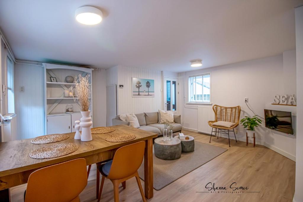a dining room and living room with a table and chairs at Carpe Diem Egmond aan Zee by Urban Home Stay in Egmond aan Zee
