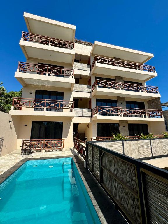 a building with a swimming pool in front of a building at Casa Zianda - Departamentos en Puerto Escondido in Brisas de Zicatela