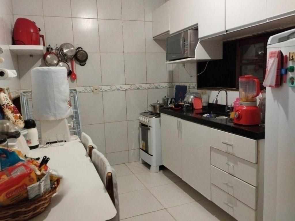 a small kitchen with a table and a sink at Quarto Praia do Frances in Marechal Deodoro