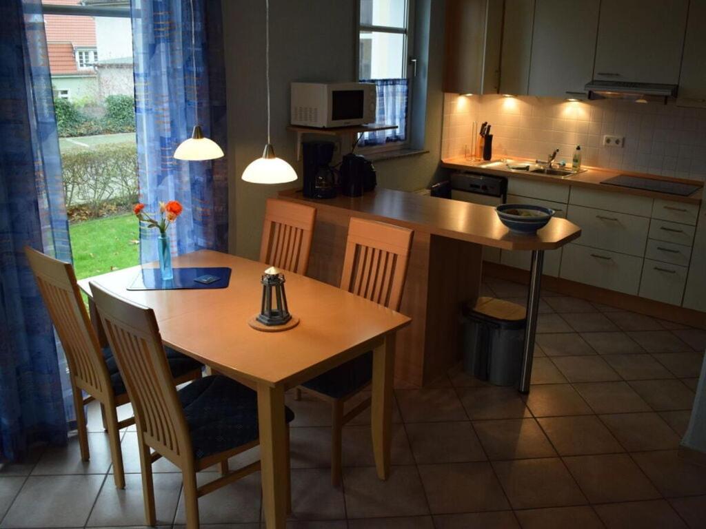 une cuisine avec une table et des chaises en bois ainsi qu'une table et une table dans l'établissement Holiday apartment seagull, à Zinnowitz