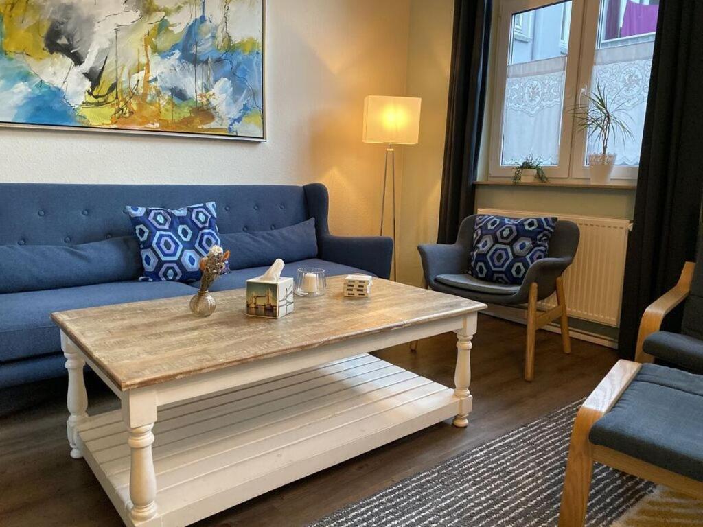 een woonkamer met een blauwe bank en een salontafel bij Stadthaus Emmy Marxen in Schleswig