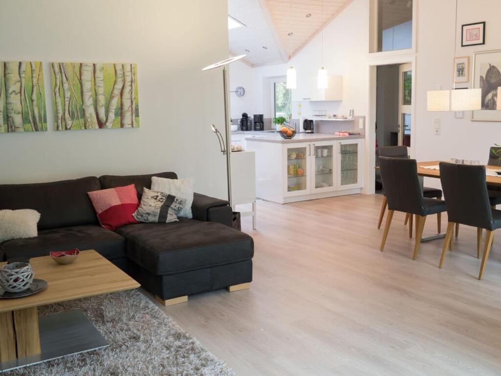 uma sala de estar com um sofá e uma sala de jantar em Holiday home Falkenweg em Holm Seppensen