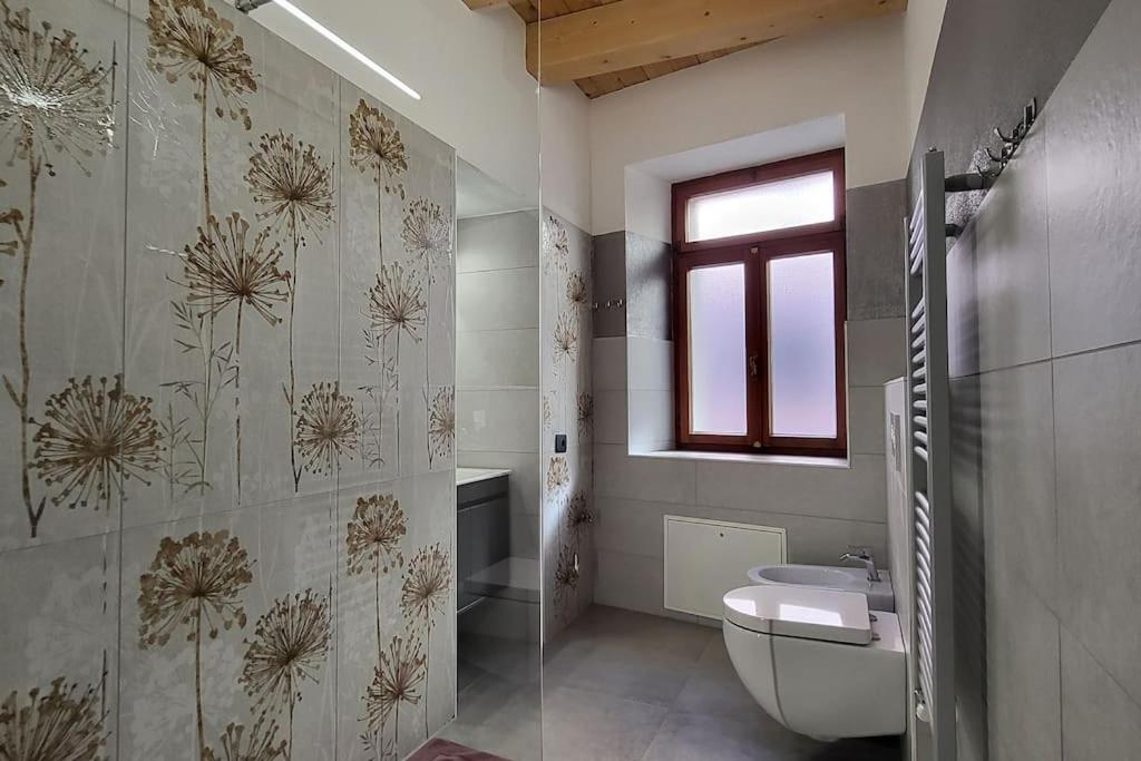 een badkamer met een toilet, een wastafel en een raam bij La Maison de Joanna 3 in Châtillon