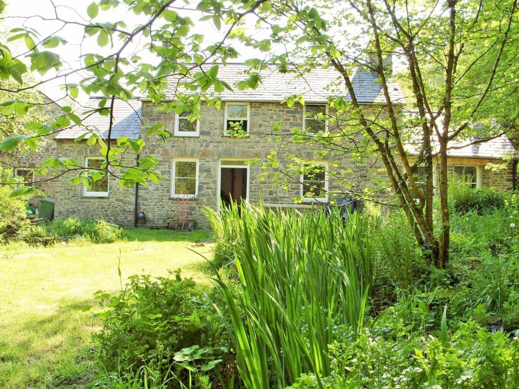 an old stone house in a yard with plants at 3 Bed in Aberaeron 55308 in Ciliau-Aeron