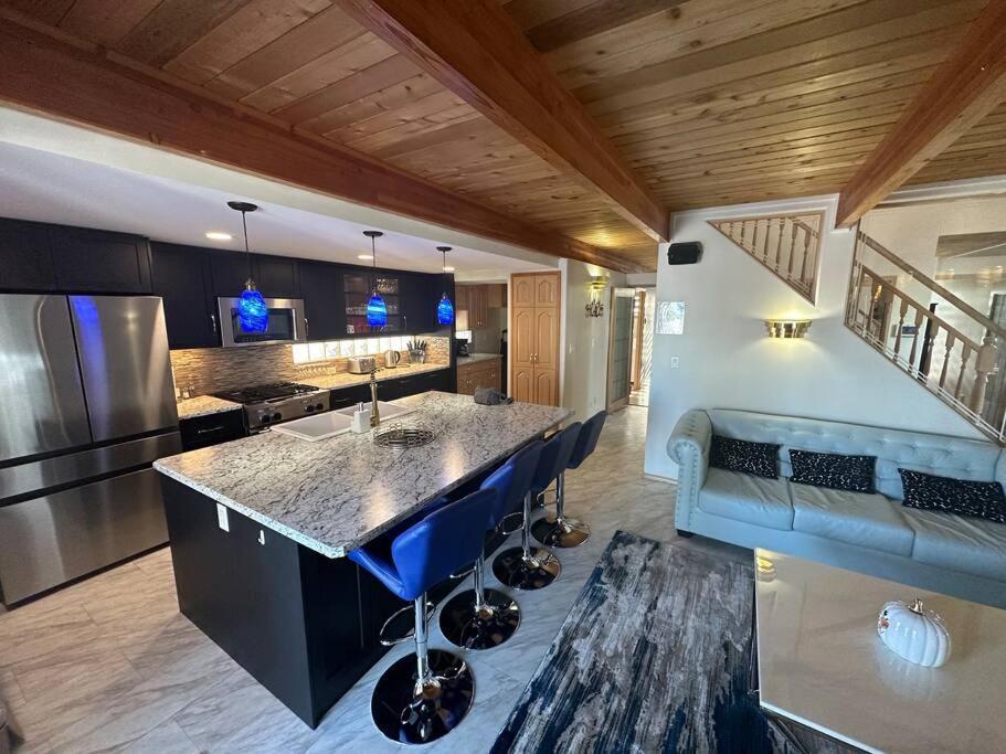 a kitchen with a large island with blue stools at Blue House in Sylvan Lake