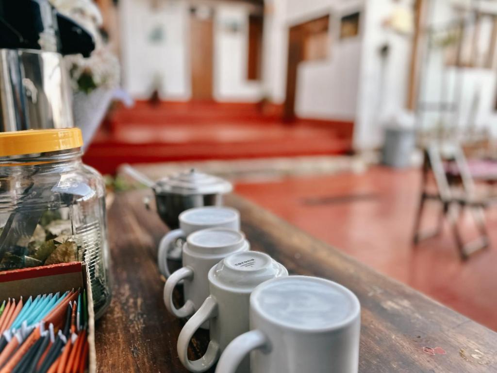 una fila di tazze di caffè sedute su un tavolo di Casa Cusco guest house a Cuzco