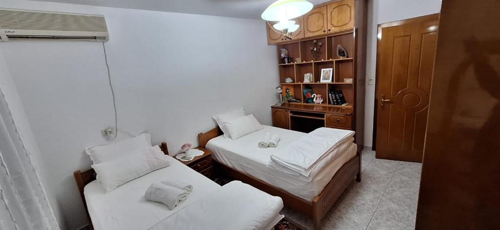 a small room with two beds and a book shelf at Marbi Guest House in Gjirokastër