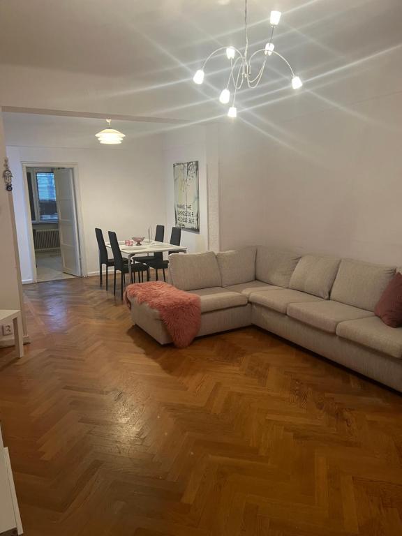 ein Wohnzimmer mit einem Sofa und einem Tisch mit Stühlen in der Unterkunft Stor lägenhet in Malmö