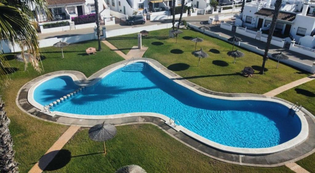 La Victoria apartament,Jumilla II, 2 bedrooms, 2 bathrooms and beautiful swimming pool في أوريويلا كوستا: اطلالة علوية على مسبح في منتجع