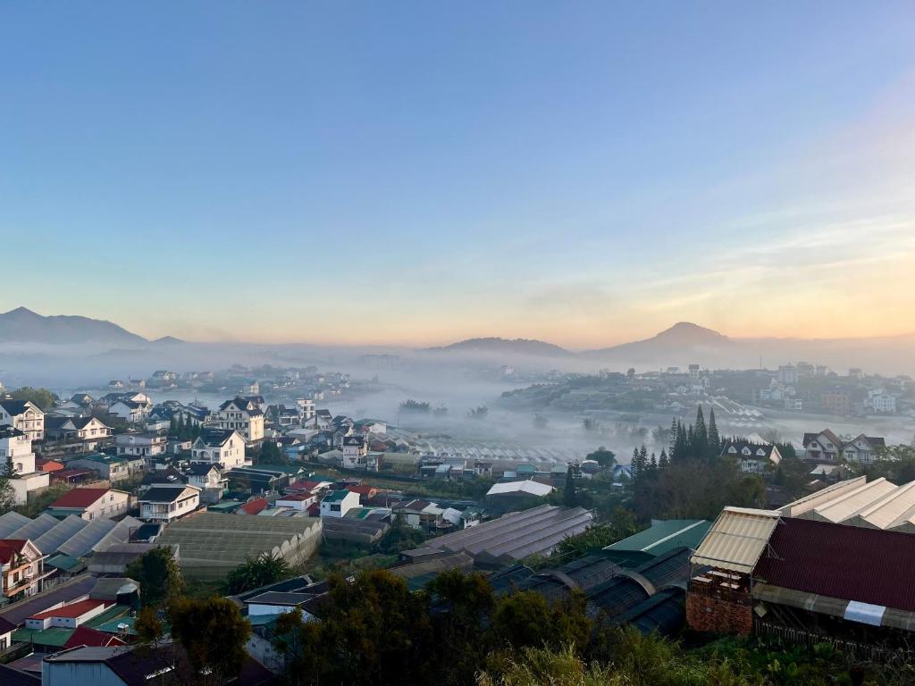 a view of a city with fog in the distance at SAFFRON Dalat in Da Lat