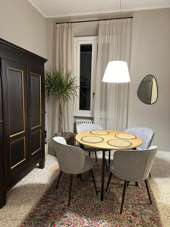 ein Esszimmer mit einem Tisch und Stühlen in einem Zimmer in der Unterkunft Room Manzoni 37 in Cremona