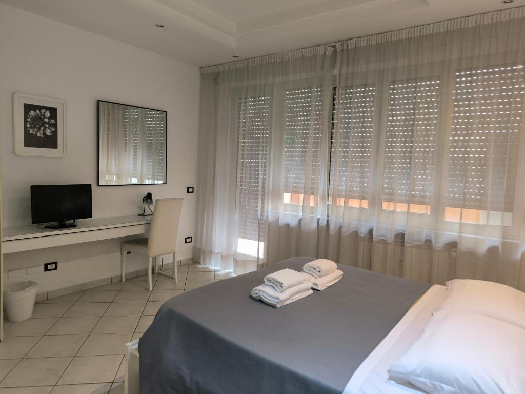 a bedroom with a bed and a desk and a television at Tre R in Rome