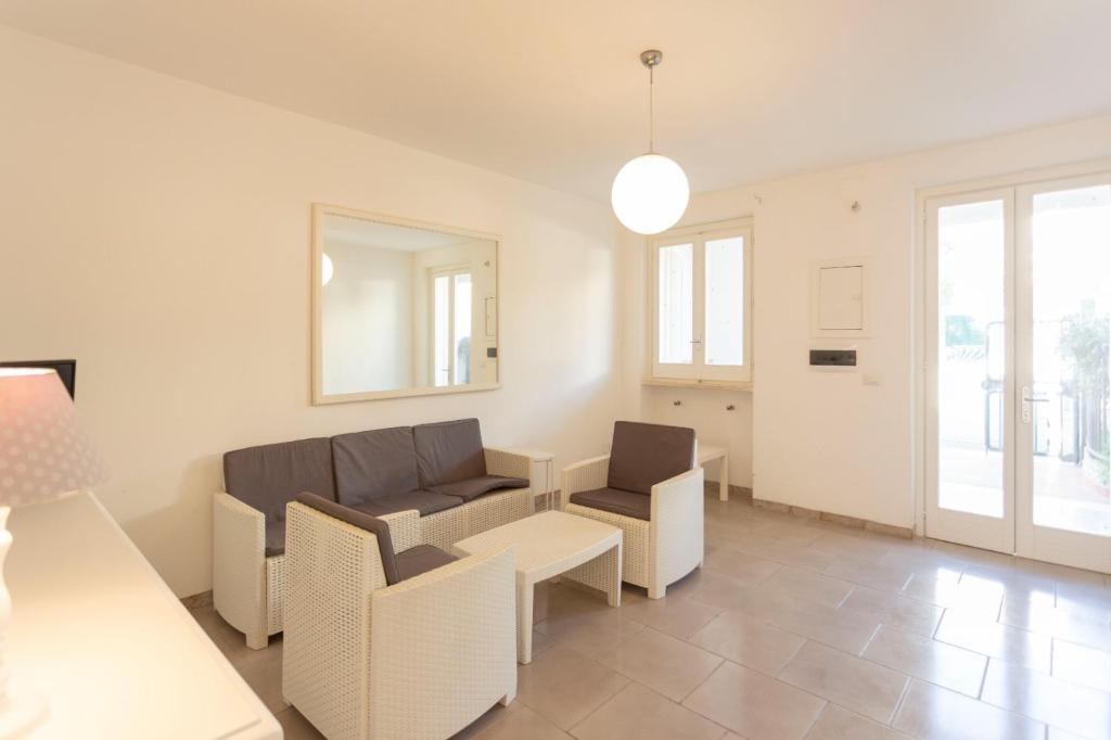 un soggiorno con un divano, sedie e un tavolo di Casa Vacanze Sole by Casavacanze di Angelo a Porto Cesareo