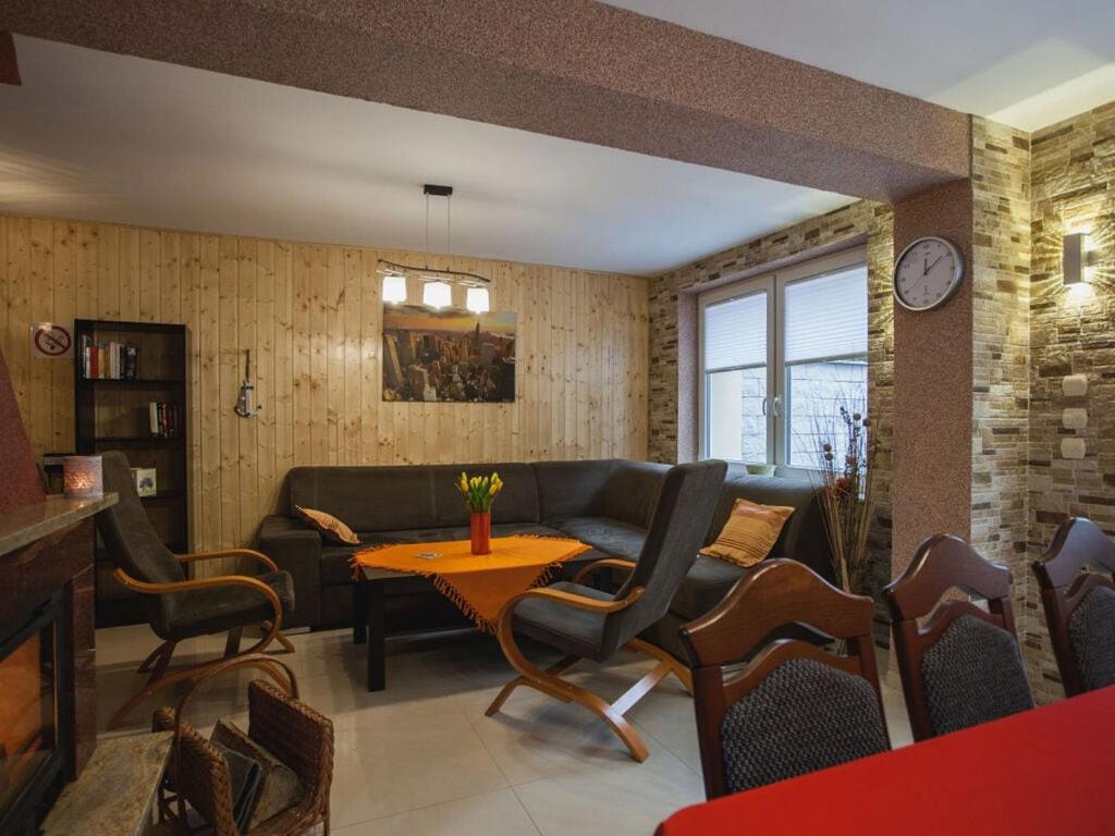 a living room with a couch and a table and chairs at Holiday apartment four seasons in Dźwirzyno