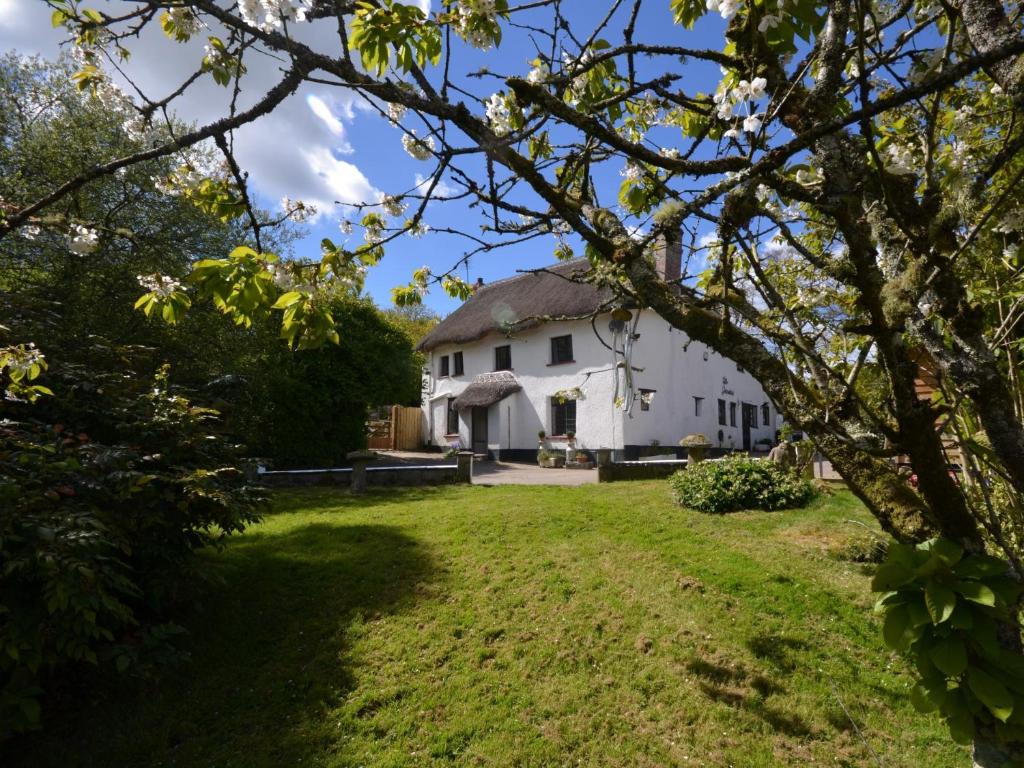 a large white house with a grass yard at 4 Bed in Dartmoor National Park 49535 in Sampford Courtenay