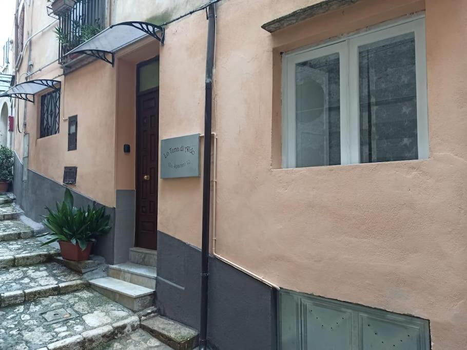 een deur naar een gebouw met een bord erop bij Intero alloggio - centro storico - La Tana di Aldo- 150 m da Pepe in Grani in Caiazzo