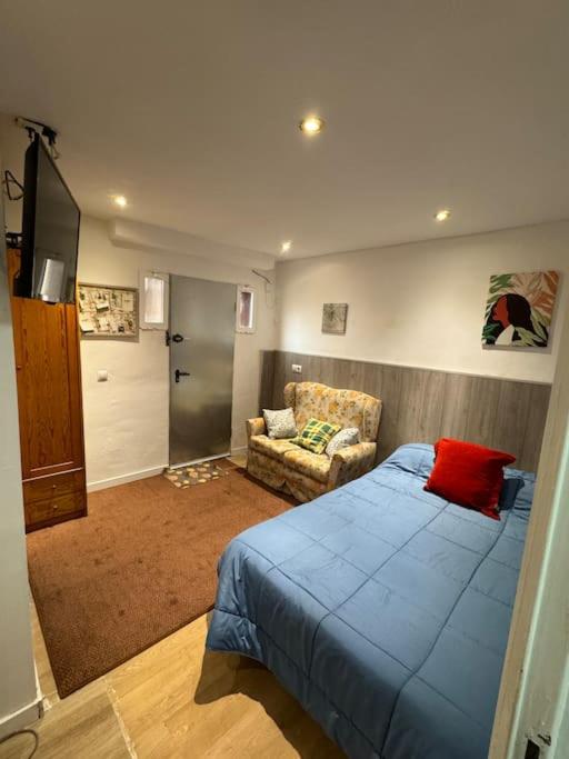 1 dormitorio con 1 cama azul y 1 sofá en Apartamento,Albares de la Ribera en Madrid